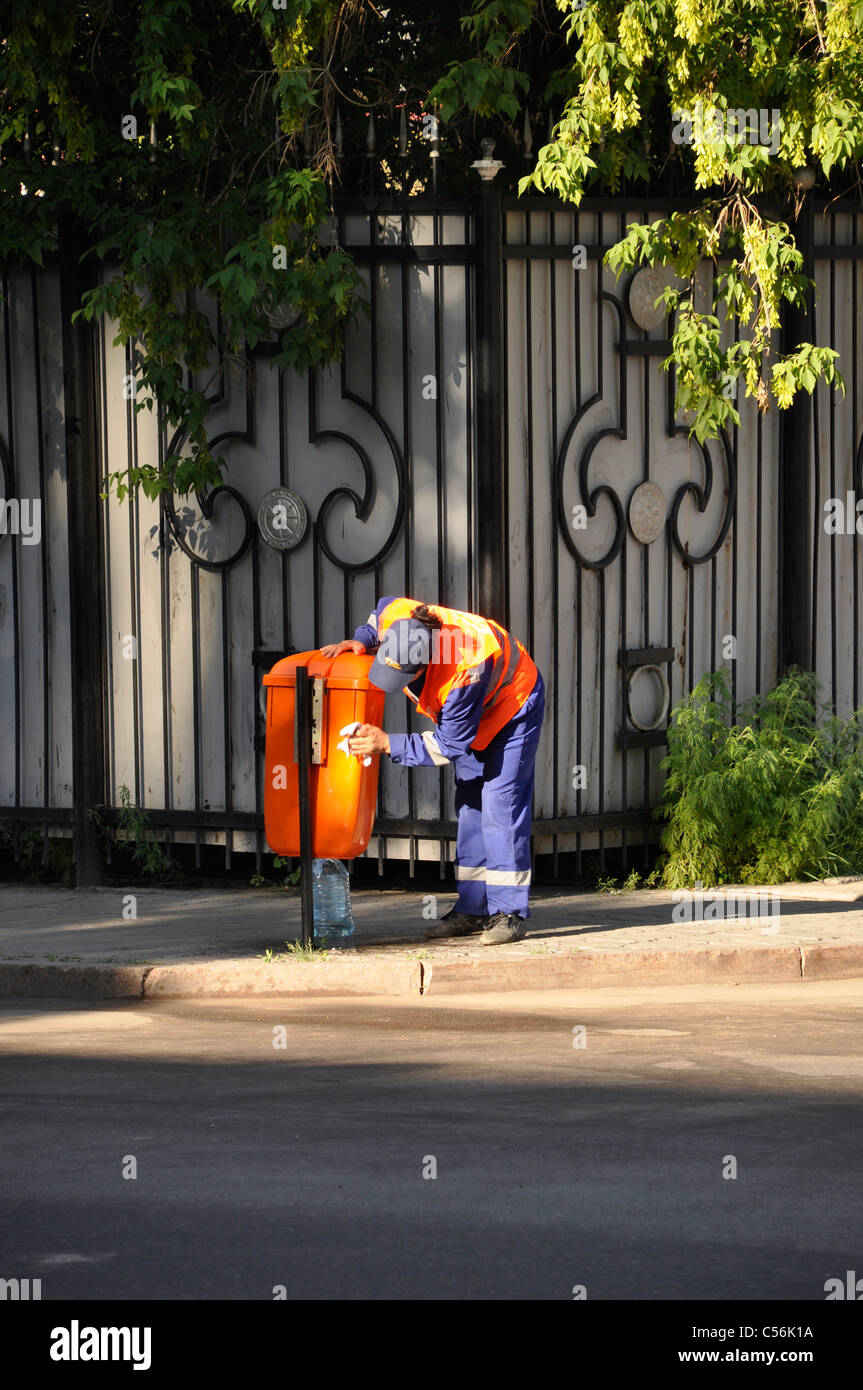 garbage man polishing dustbin Astana Kazakhstan Central Asia Stock Photo