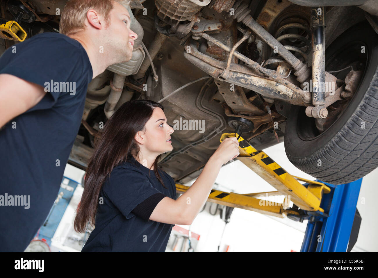 Two mechanics looking at a car discussing a problem Stock Photo