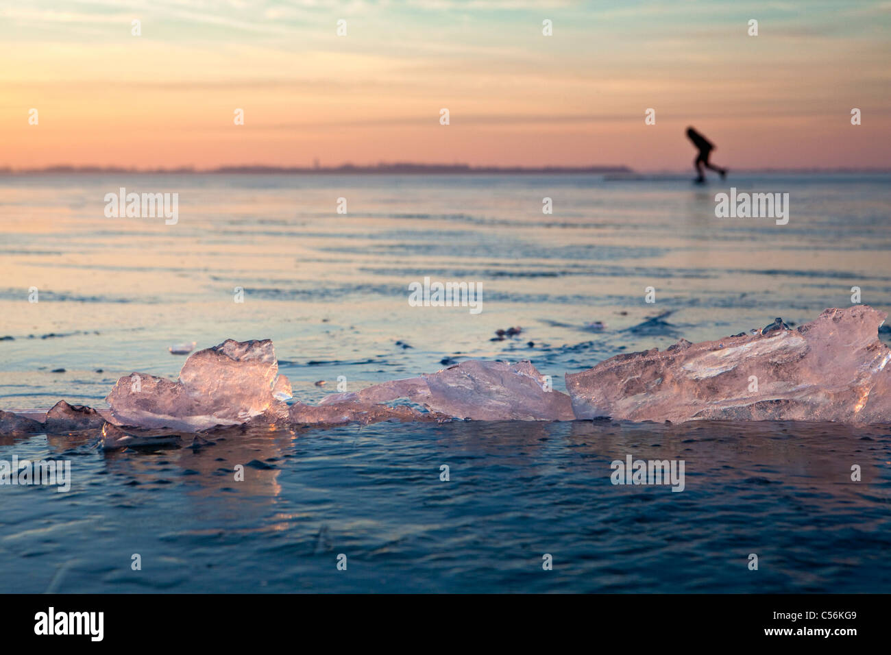 The Netherlands, Marken, Frozen lake called IJsselmeer. Sunset. Ice skating. Stock Photo