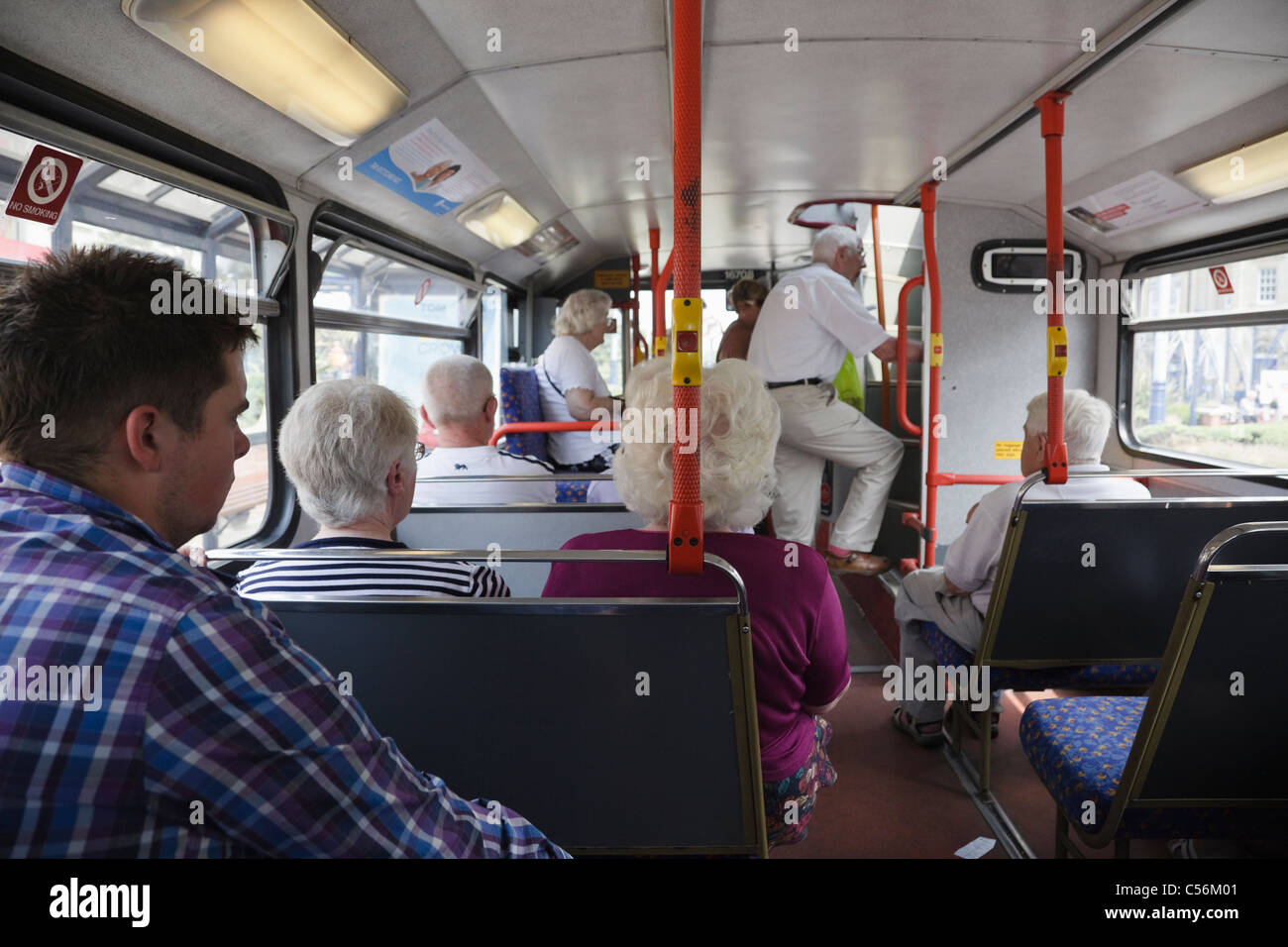 People passengers using public transport travelling on a local bus ...