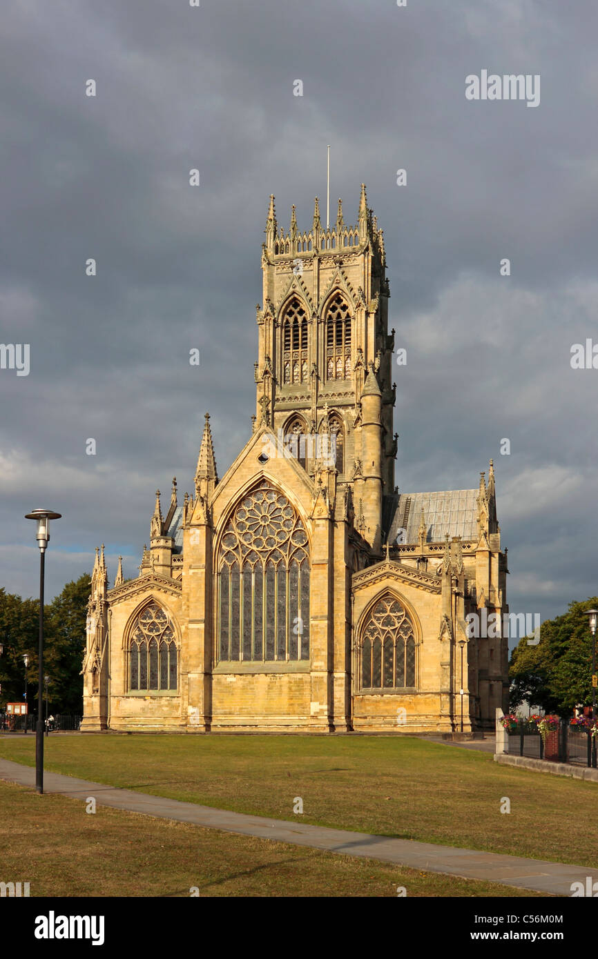 Doncaster Minster, St Georges Church in bright morning sun against a dark angry sky. Stock Photo