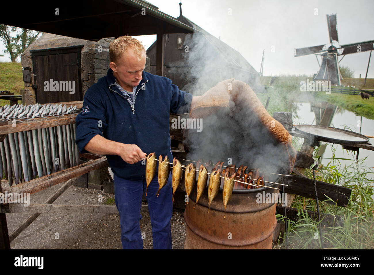 The Netherlands, Enkhuizen. Museum called Zuiderzeemuseum. Man showing the traditional way of smoking fish and eel. Stock Photo
