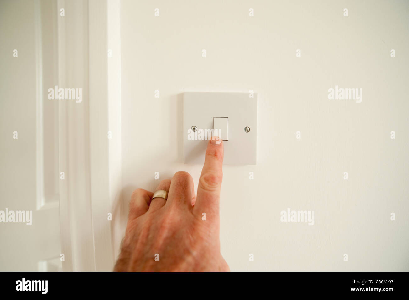Hand turning on a light switch Stock Photo