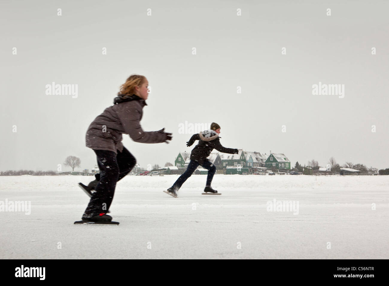 The Netherlands, Marken, Boy and girl competing for local ice skating championship. Stock Photo