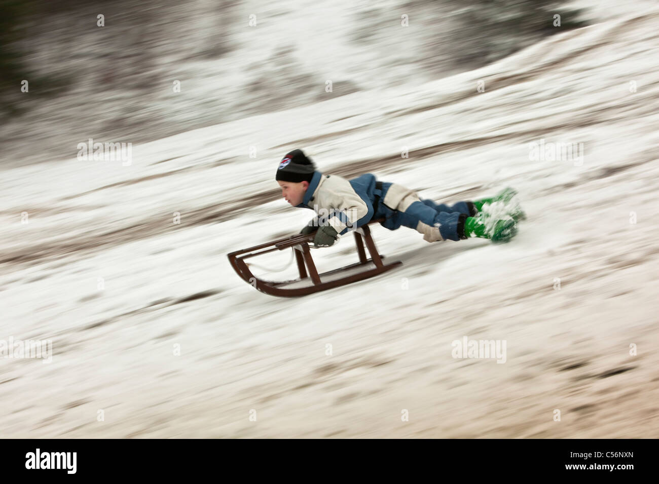 The Netherlands, Egmond aan Zee, Boy sledging. Stock Photo