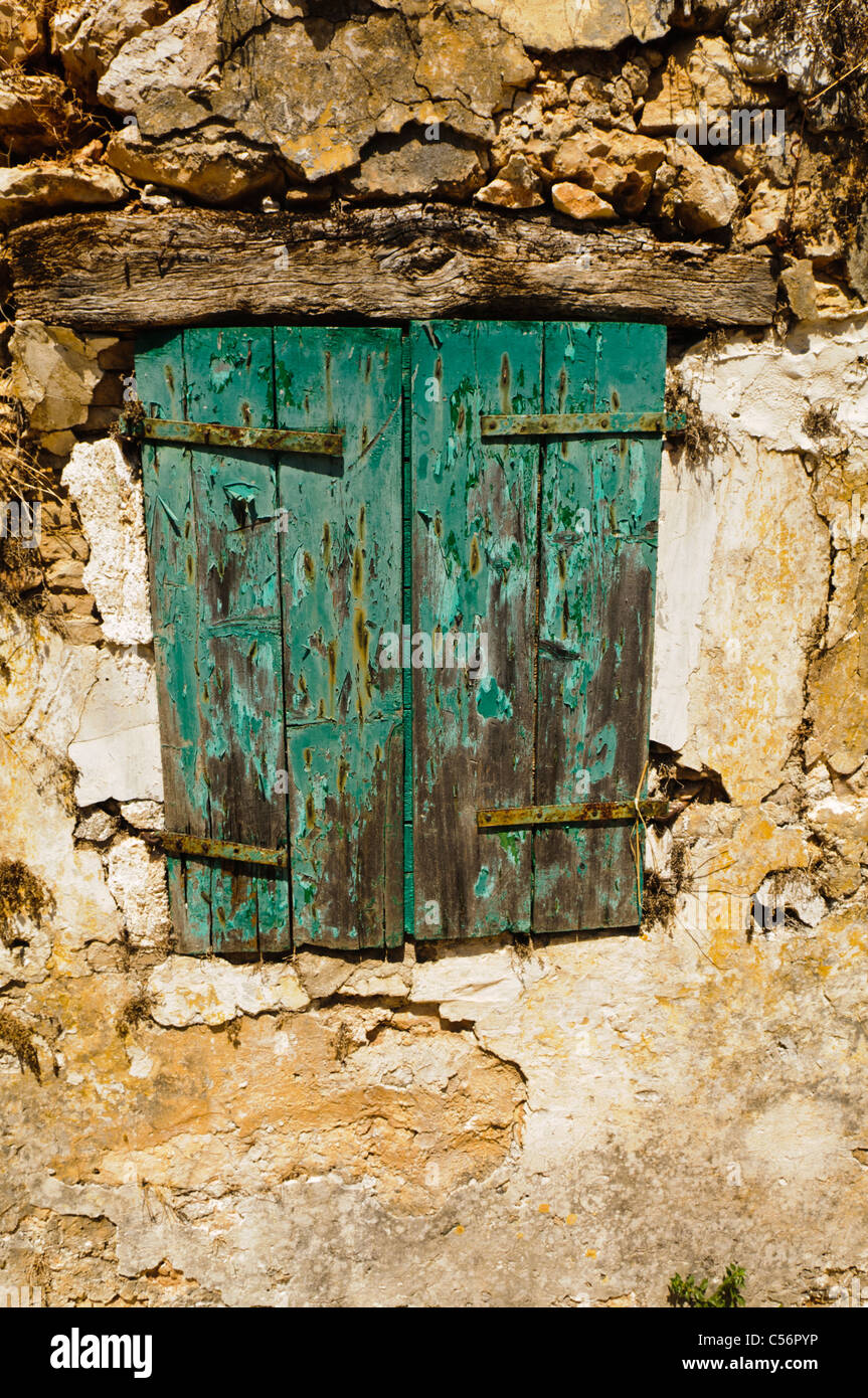 Old wooden shutters on a stone wall with peeling paint Stock Photo - Alamy