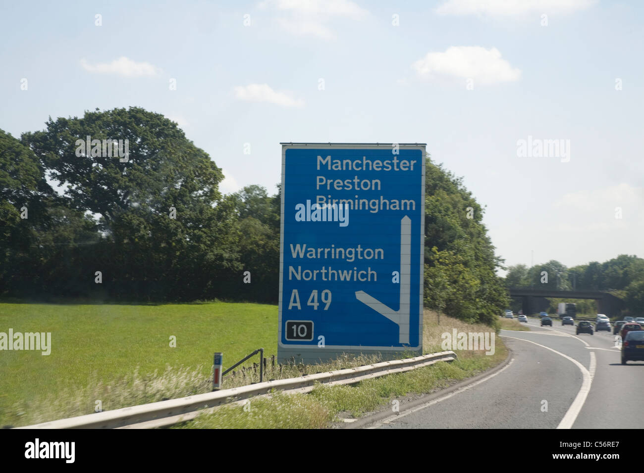 Cheshire England UK M56 Motorway Junction sign showing information to with fast moving traffic Stock Photo