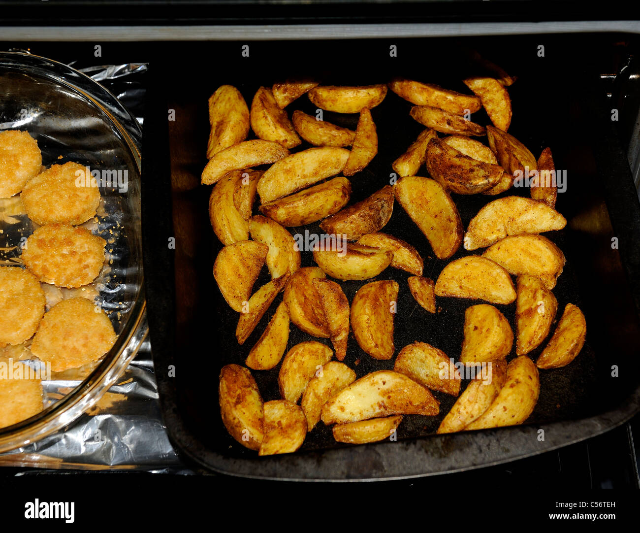 potato wedges cooking in the oven england uk Stock Photo Alamy