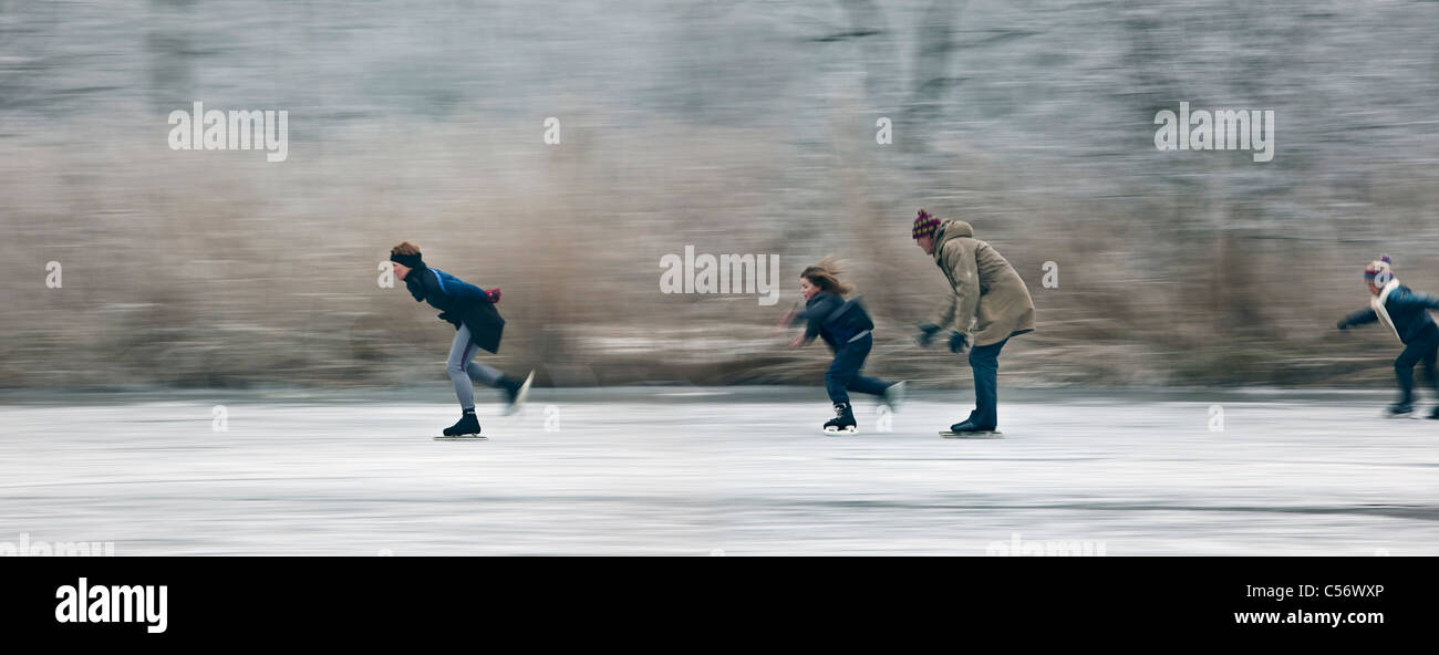 The Netherlands, Ankeveen. People ice skating. Motion blurred. Stock Photo