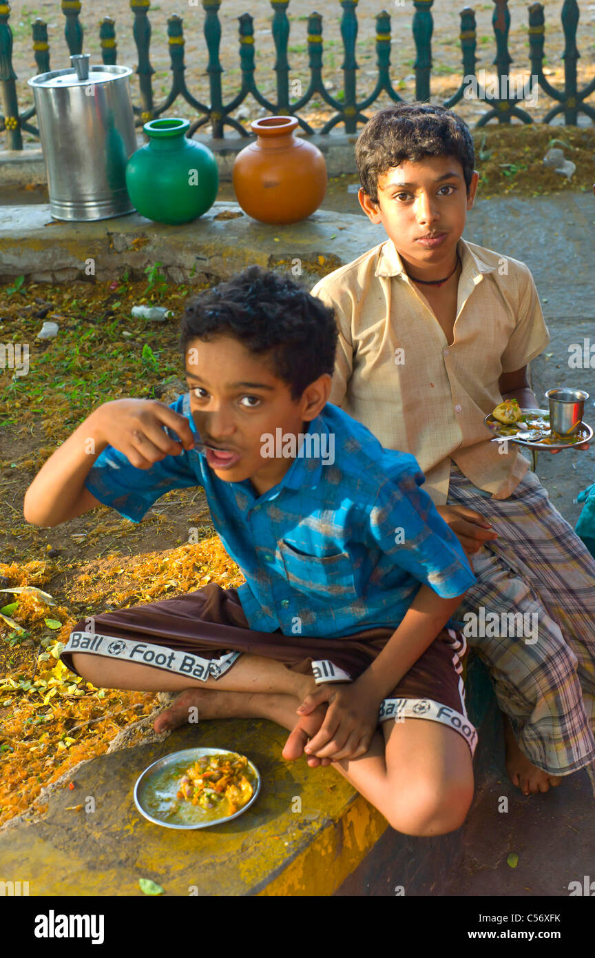 Children eating indian street food in Mysore, Karnataka state, India. Stock Photo