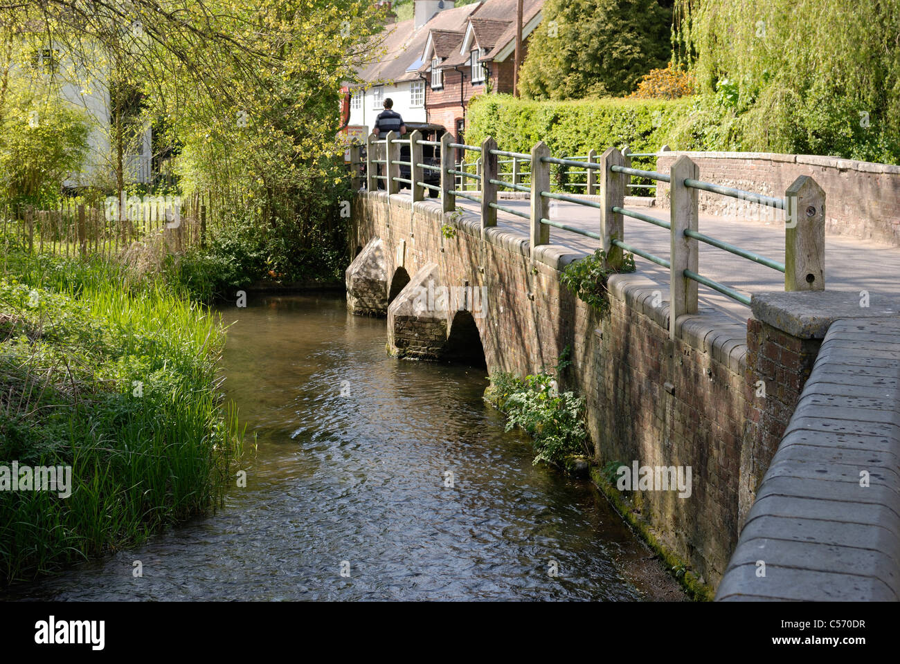 The River Darent flowing beside the road and under the bridge at the village of Shoreham. Kent. England Stock Photo