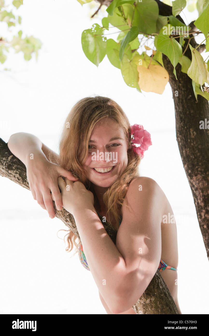 Woman standing under tree on beach Stock Photo - Alamy