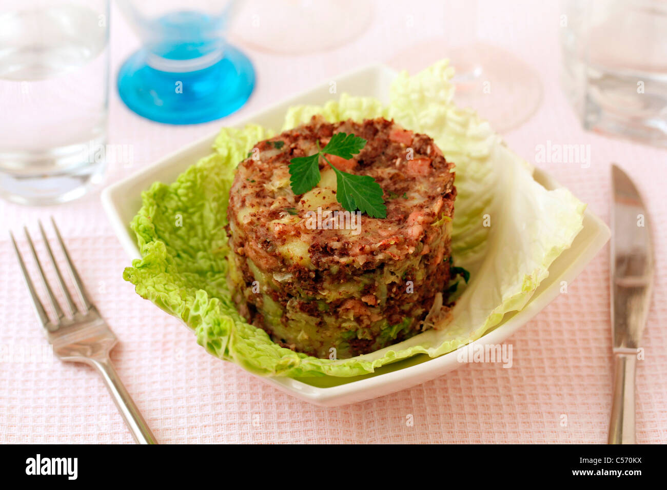 Mashed cabbage and potatoes fried with black sausage. Recipe available. Stock Photo