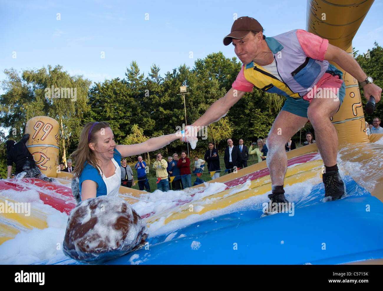 competitor getting a helping hand  during one of the its a knock out challenges which involved lots and lots of foam Stock Photo