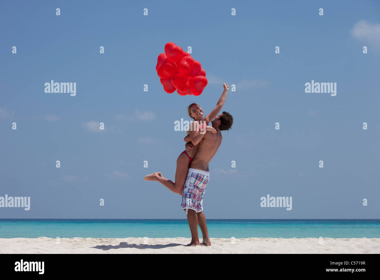 Hugging Balloons Couple hugging with balloons on beach Stock Photo - Alamy
