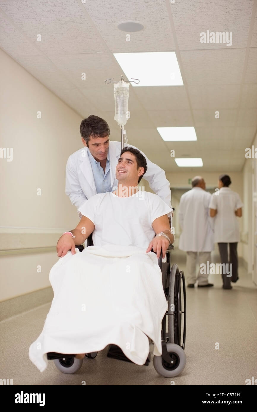 Doctor Pushing Patient In Wheelchair Stock Photo Alamy