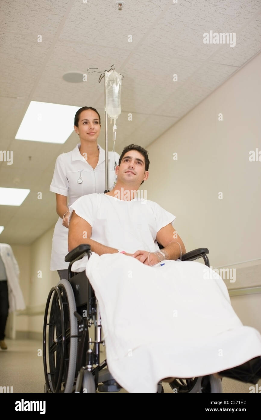 Nurse pushing patient in wheelchair Stock Photo Alamy