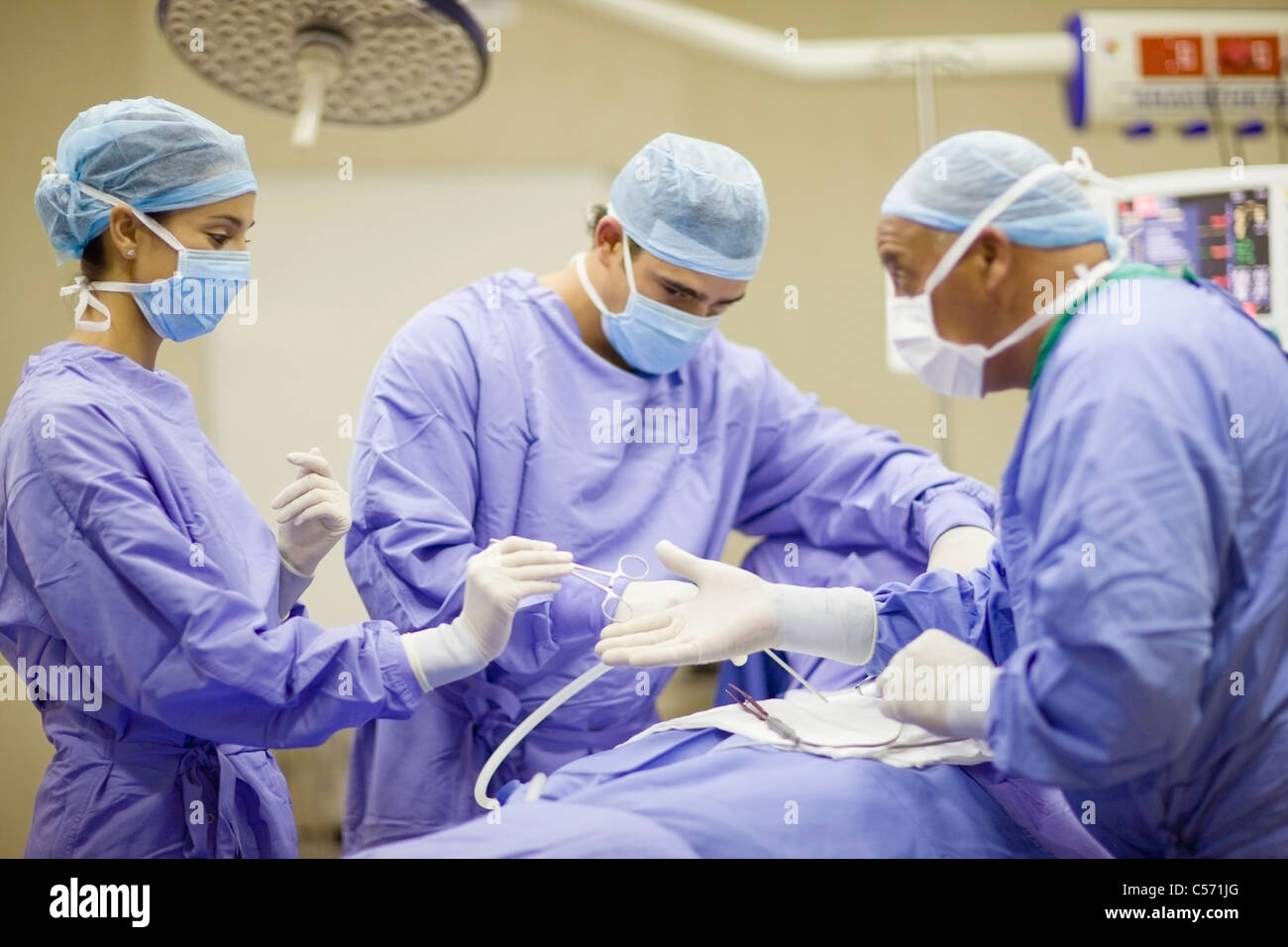 Doctor and nurses performing operation Stock Photo