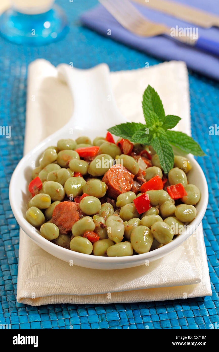 Little broad beans with chorizo. Recipe available Stock Photo Alamy