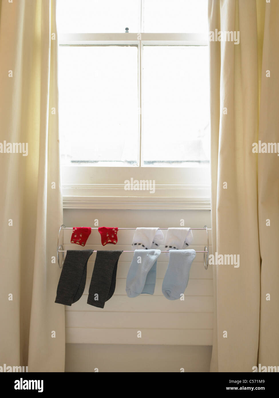 Socks hanging on rack over radiator Stock Photo - Alamy