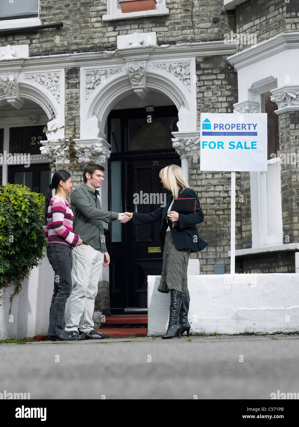Realtor showing couple property for sale Stock Photo