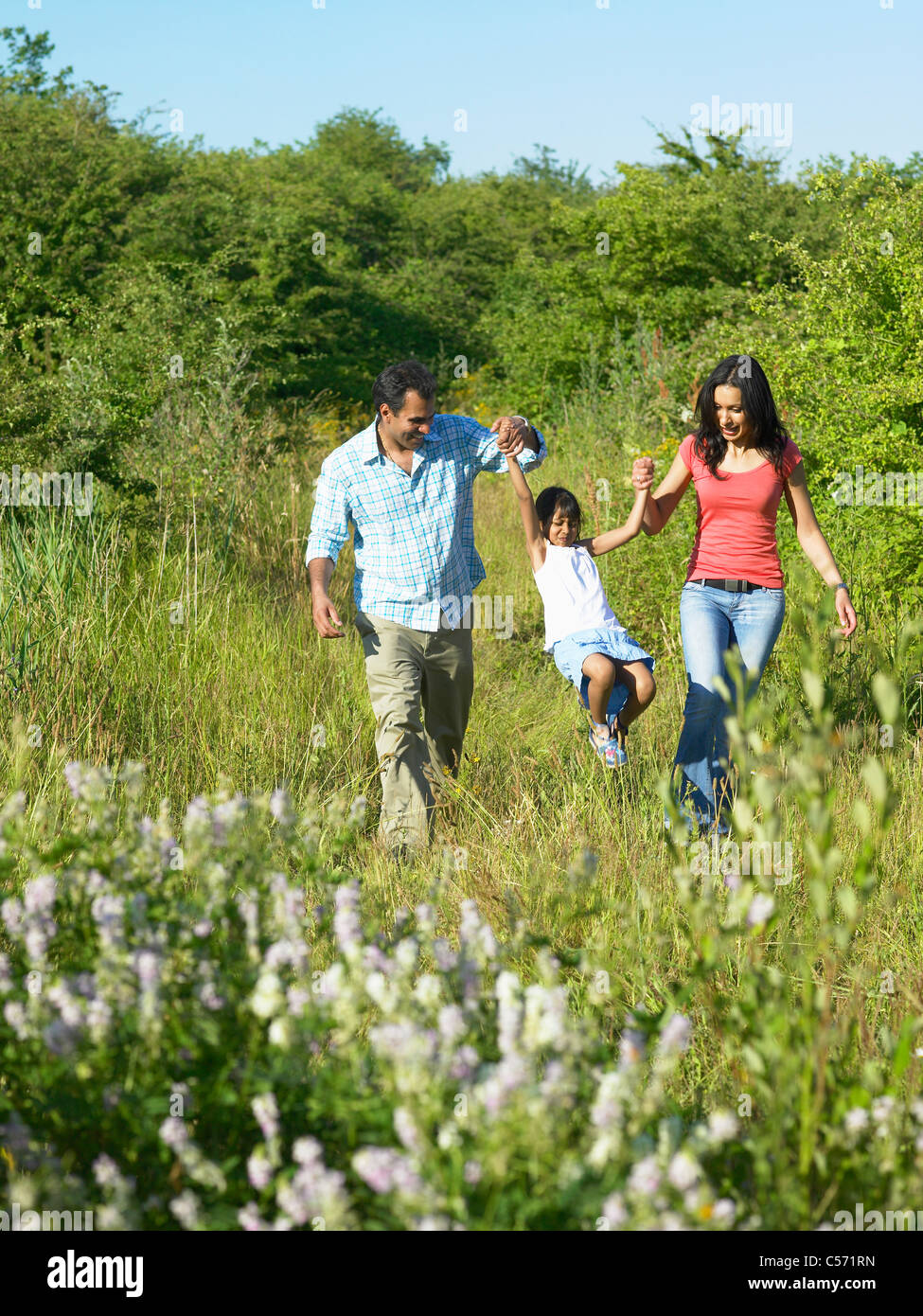 Family walking in field of flowers Stock Photo