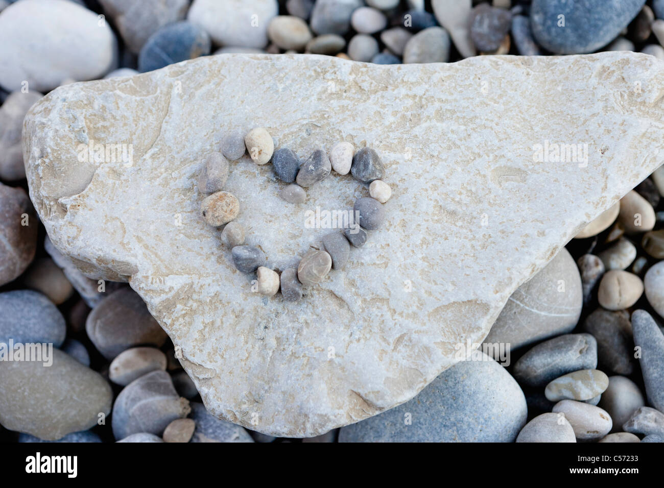 Pebbles forming heart on stone Stock Photo