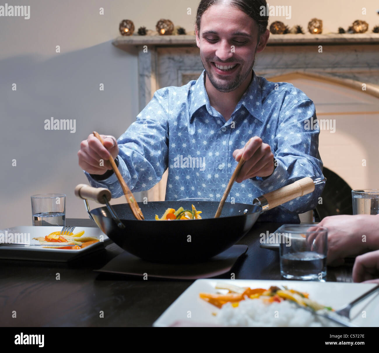 Man serving dinner from wok Stock Photo - Alamy