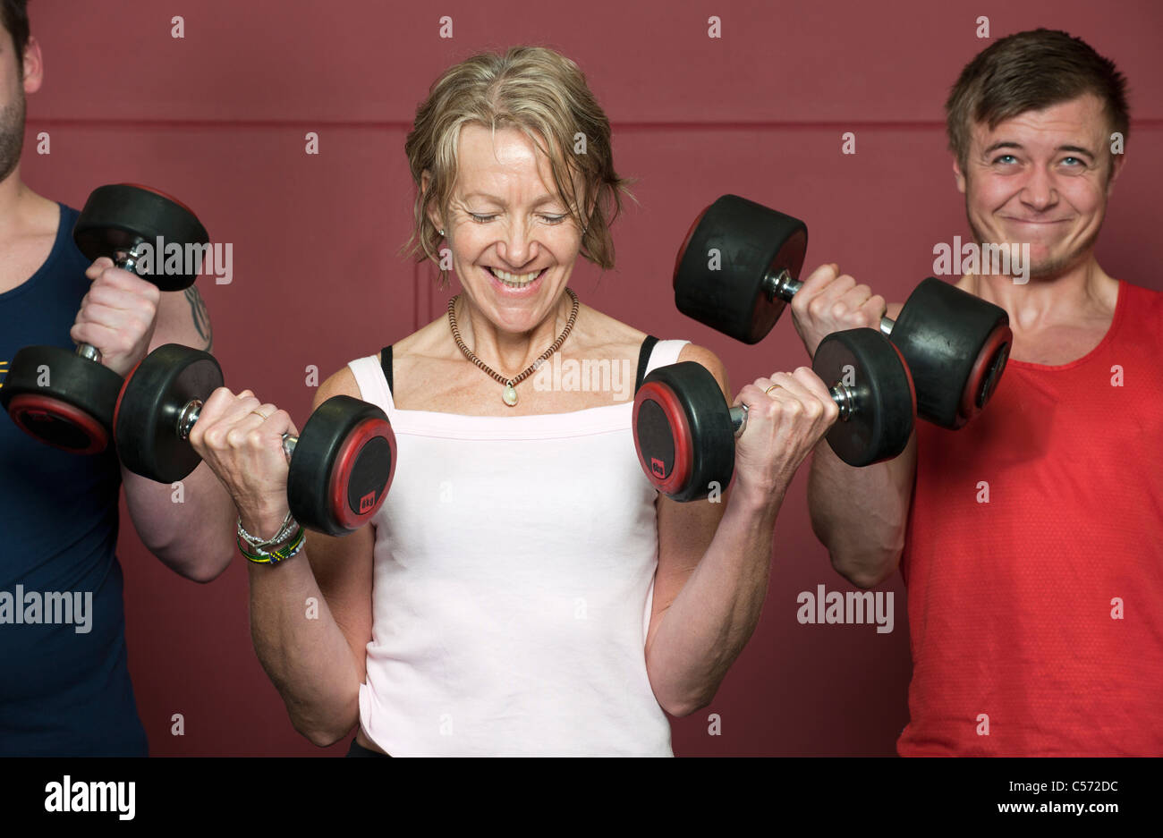 Older people lifting weights in gym Stock Photo