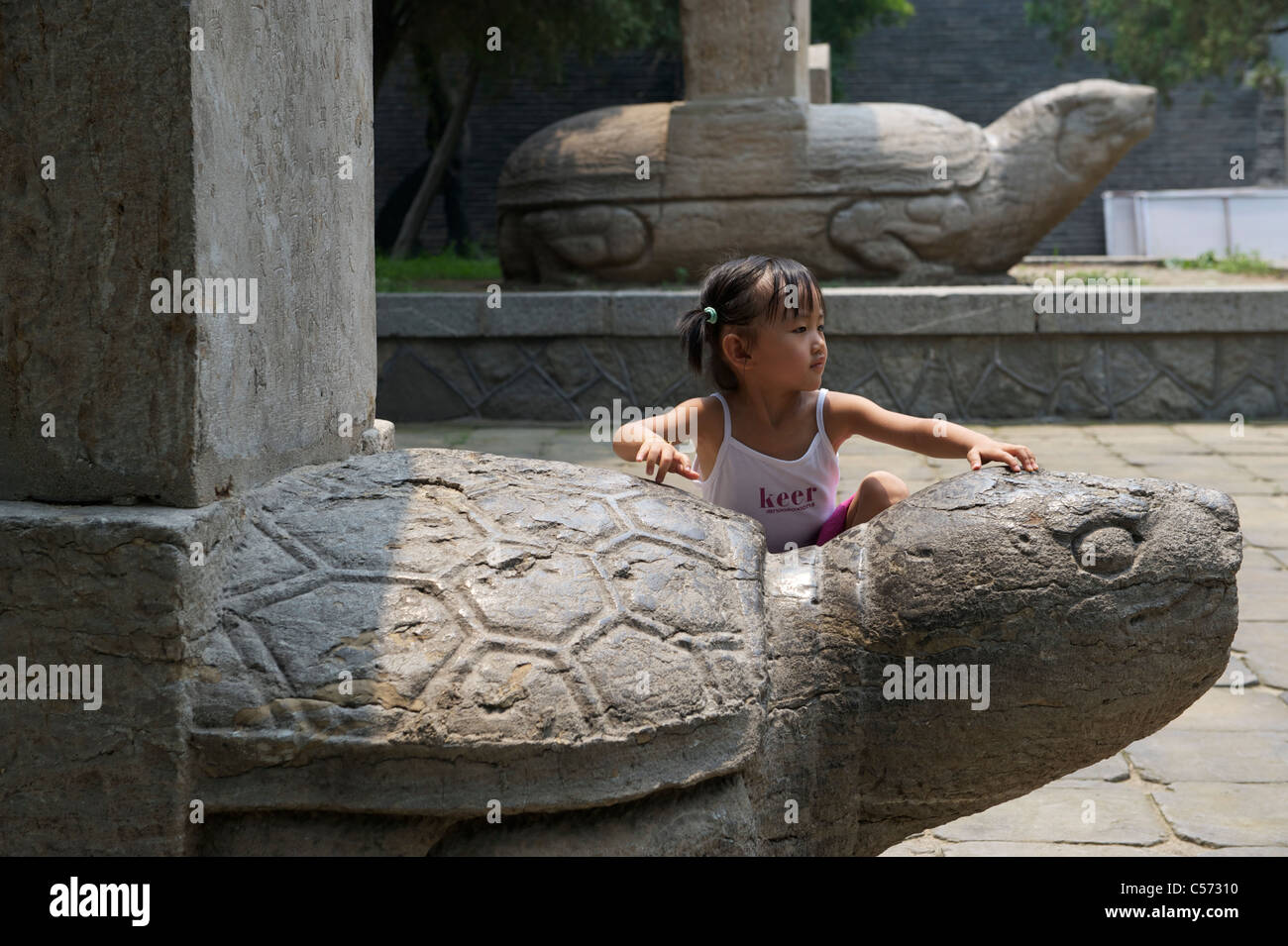 A girl stands by a Bixi at Dai Temple in Shandong, China. 10-Jul-2011 Stock Photo