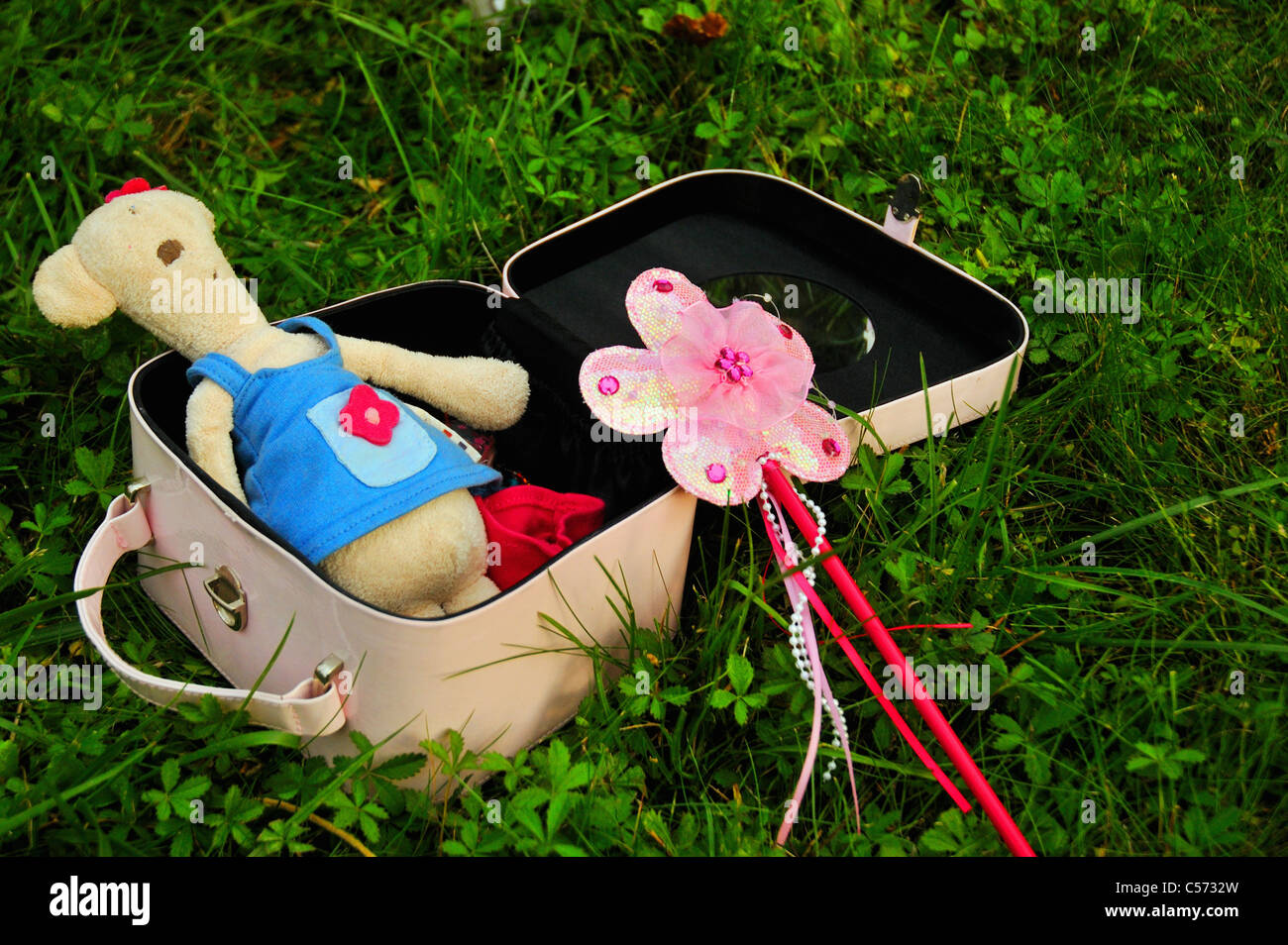 Suitcase with teddy bear and wand Stock Photo