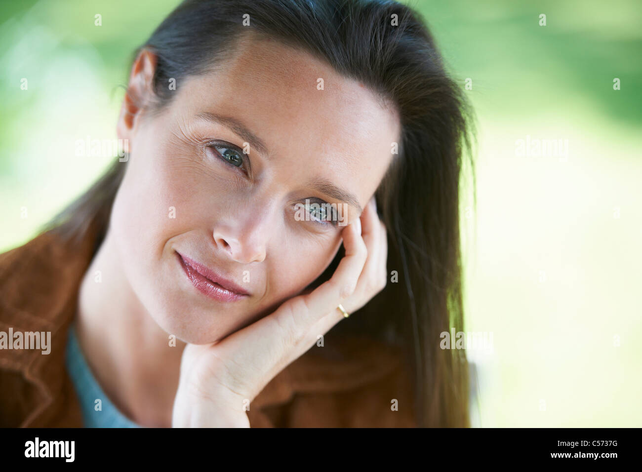 Woman resting chin in hand Stock Photo