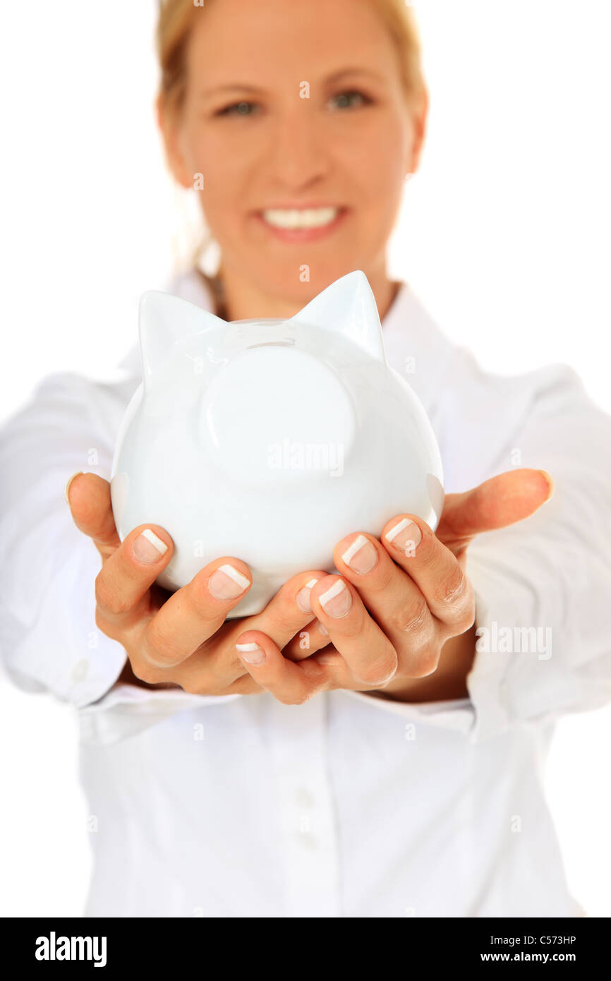 Mature woman holding piggy bank. All on white background. Selective focus on piggy bank in foreground. Stock Photo