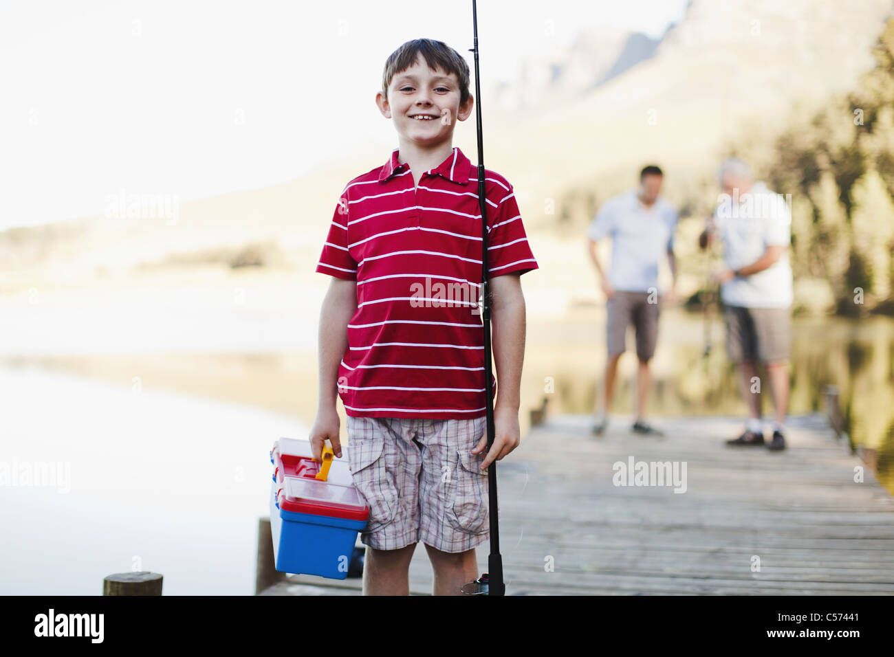 Boy carrying fishing rod on jetty Stock Photo Alamy