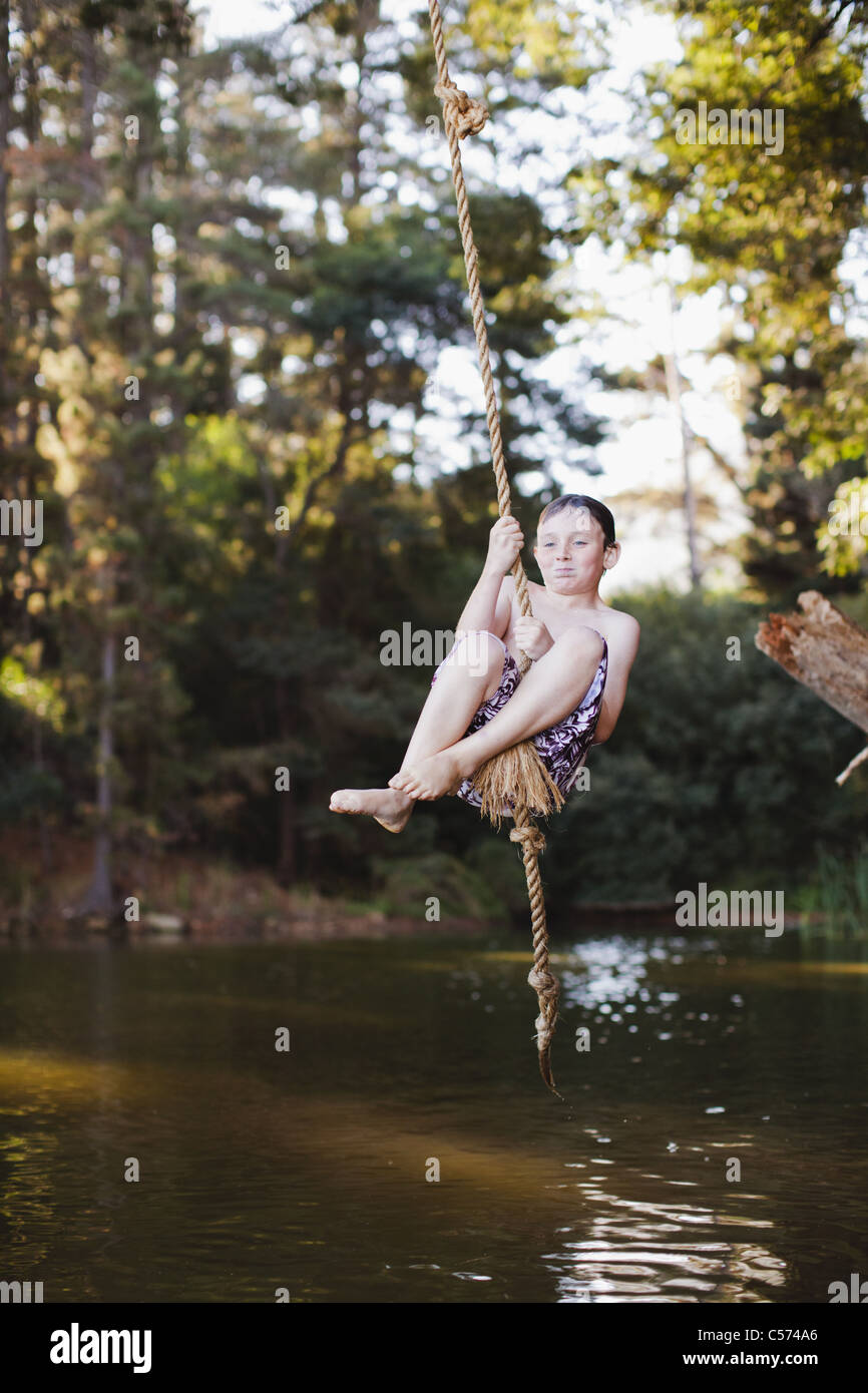 Young girl using rope swing over lake Stock Photo Alamy