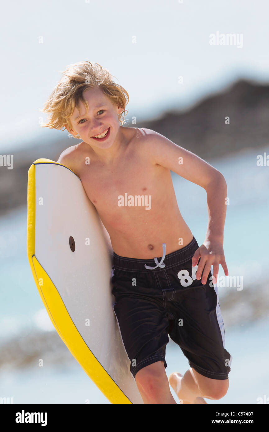 Boy carrying surfboard on beach Stock Photo Alamy