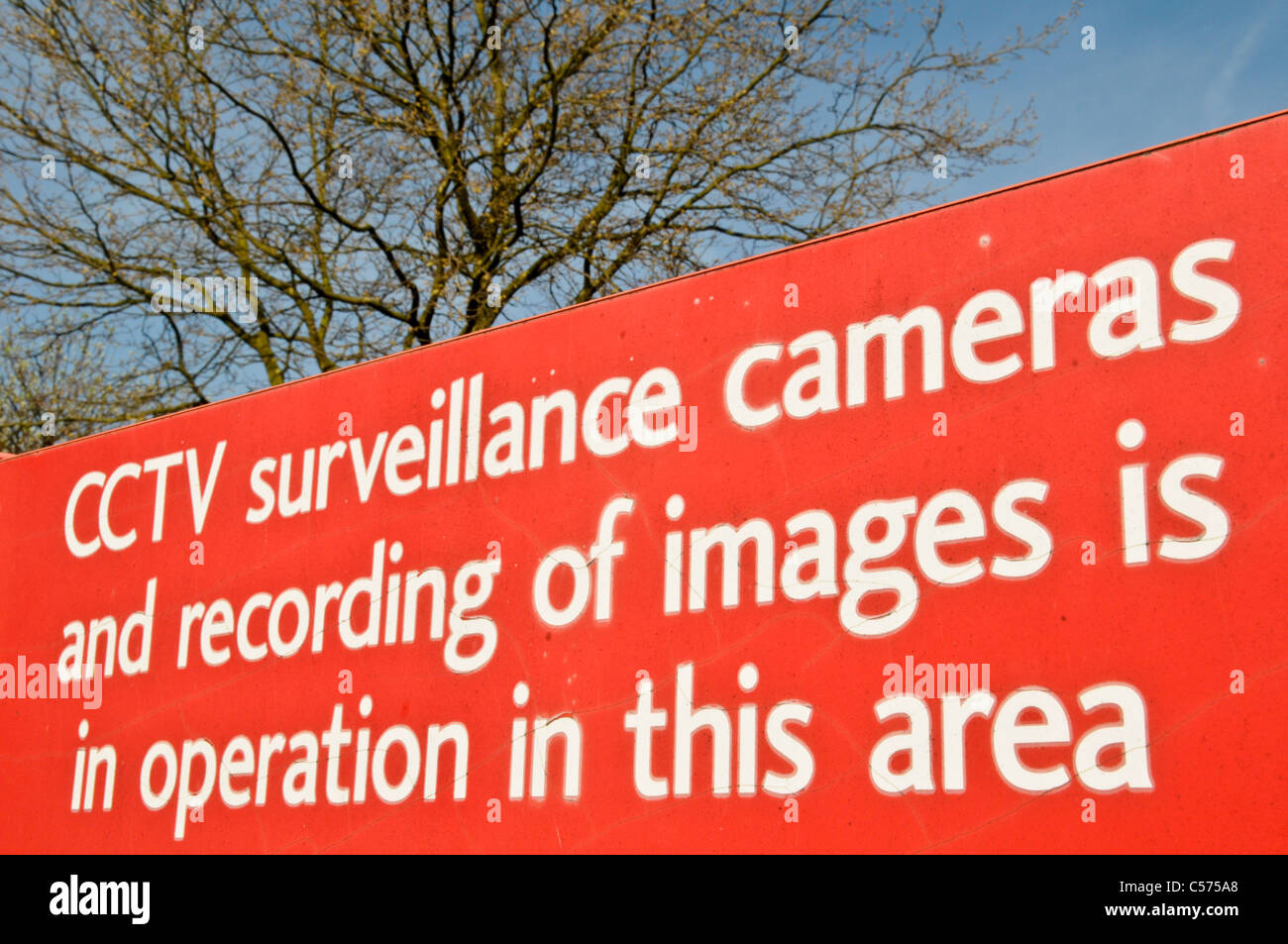 Red CCTV surveillance sign warning people cameras in operation on a council car park Stock Photo