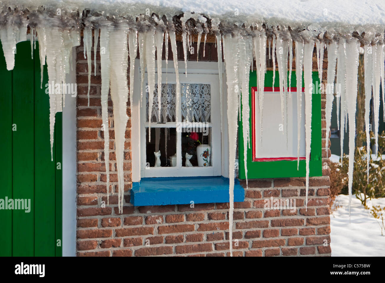 The Netherlands, Staphorst, Winter, Icicles on farm roof. Stock Photo