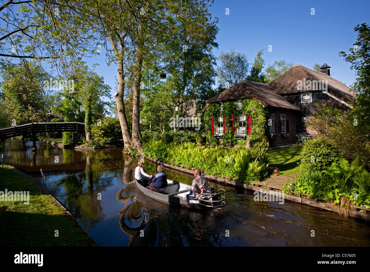 The Netherlands, Giethoorn, Village with almost only waterways. Tourists enjoying boat ride. Stock Photo