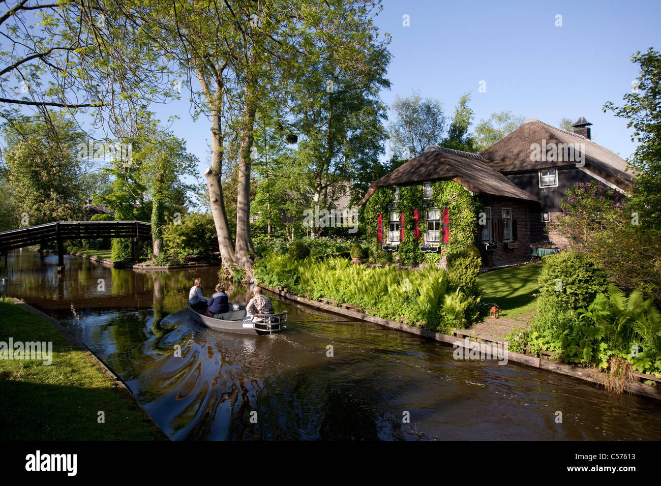 The Netherlands, Giethoorn, Village with almost only waterways. Tourists enjoying boat ride. Stock Photo