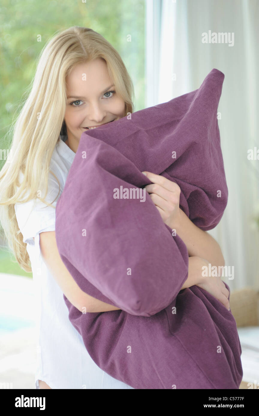 Woman hugging pillow at home Stock Photo Alamy