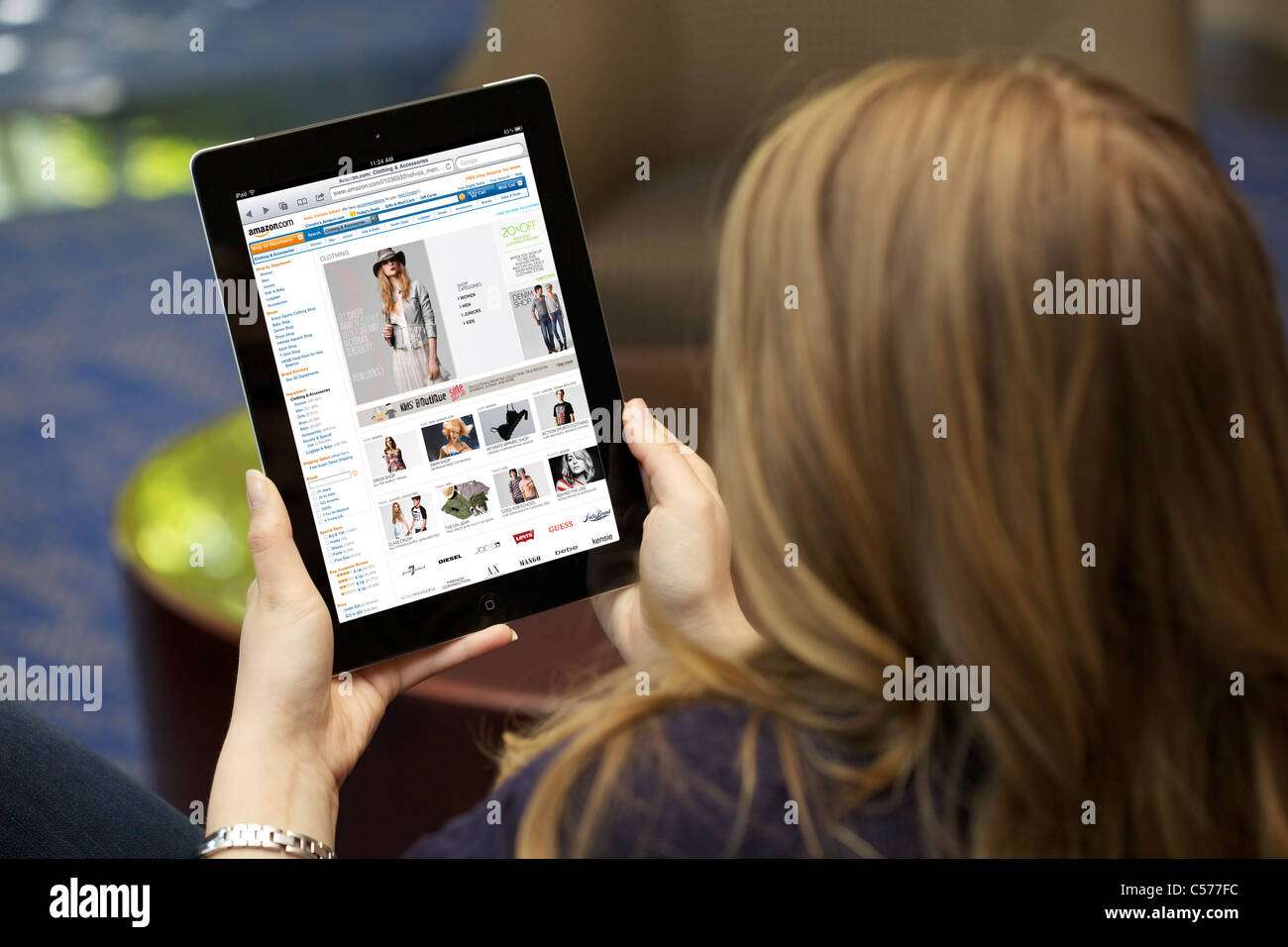 Close up view of a young Caucasian woman browsing Amazon online shopping store on an iPad 2 with wireless internet connection Stock Photo