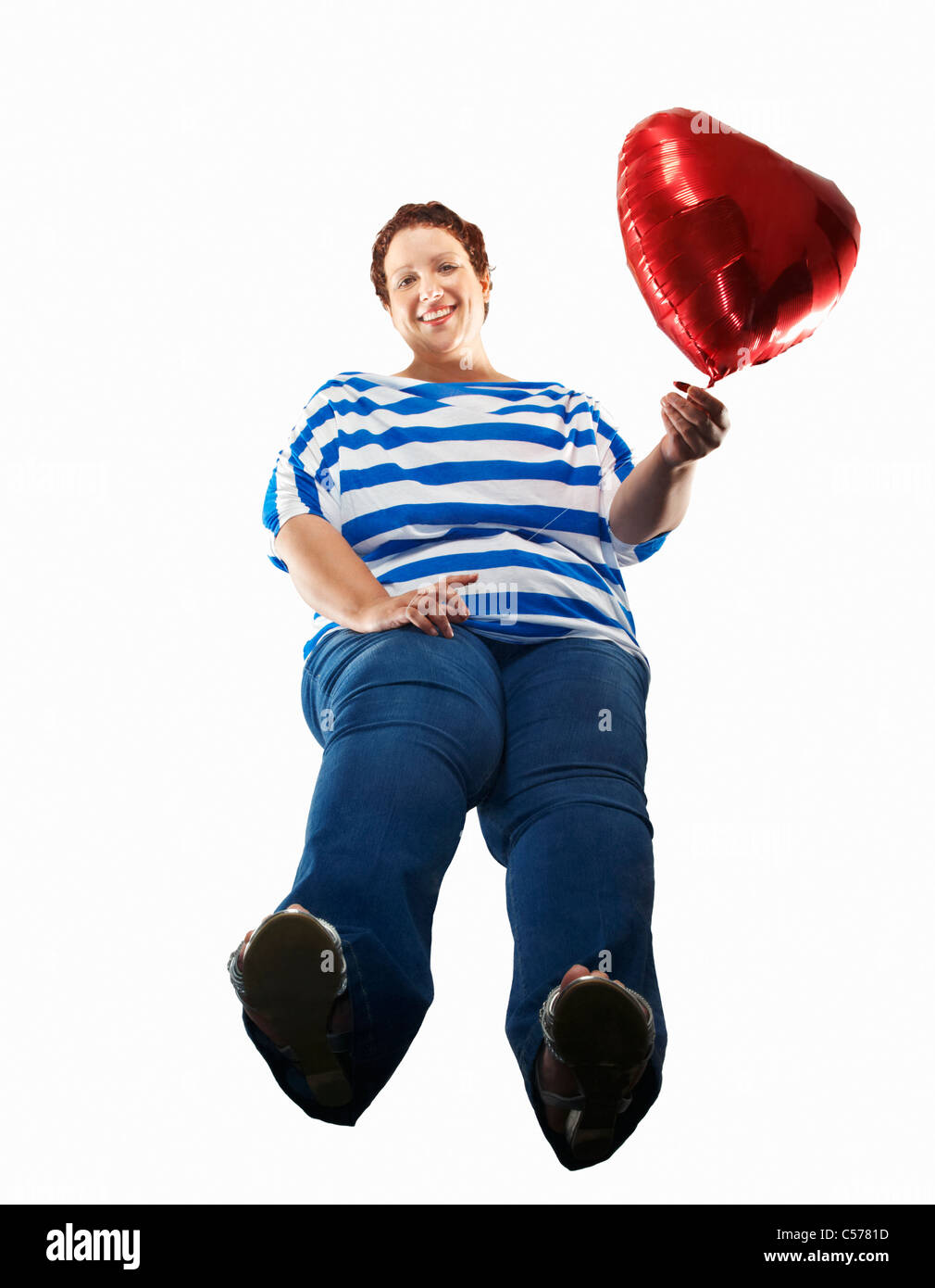 Large woman carrying heart balloon Stock Photo