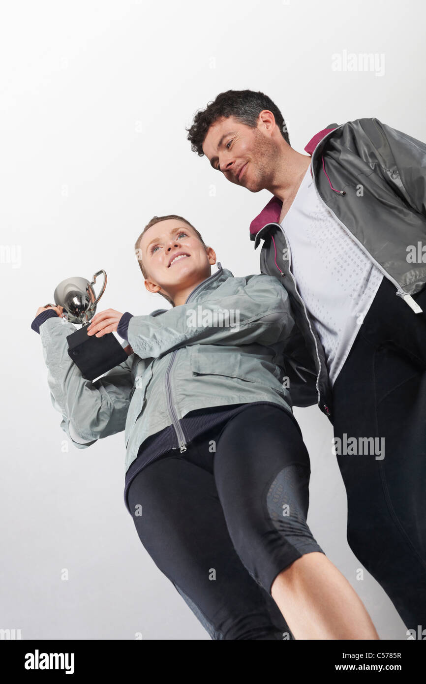 Couple in running gear holding trophy Stock Photo