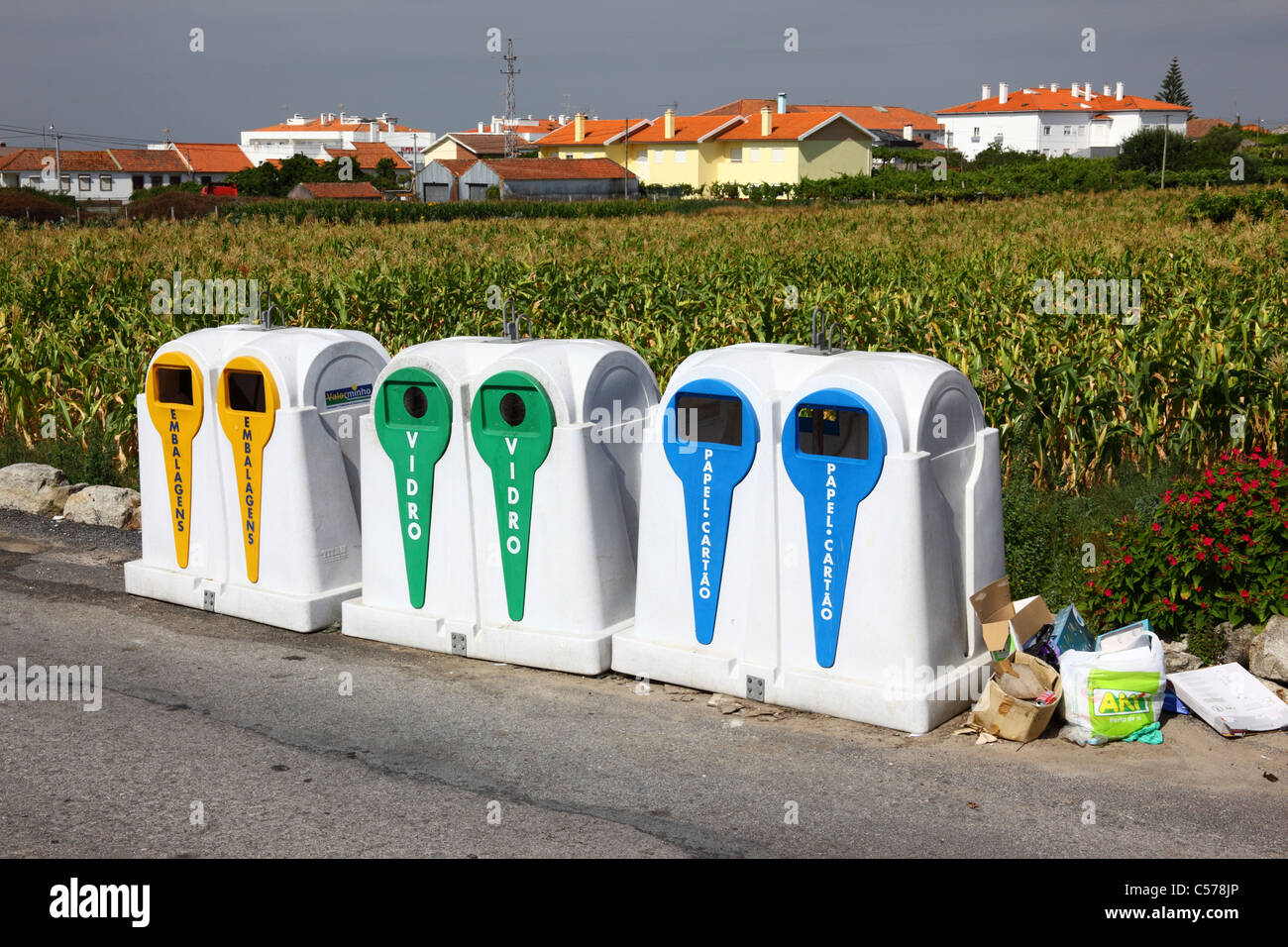 Recycling bins next to maize field and housing estate, Vila Praia de Ancora, northern Portugal Stock Photo