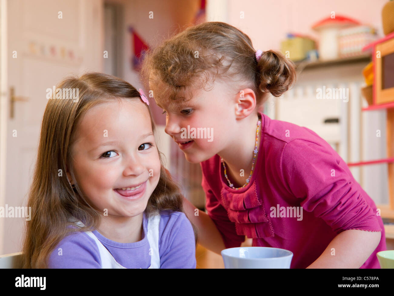 Girls whispering to each other Stock Photo - Alamy