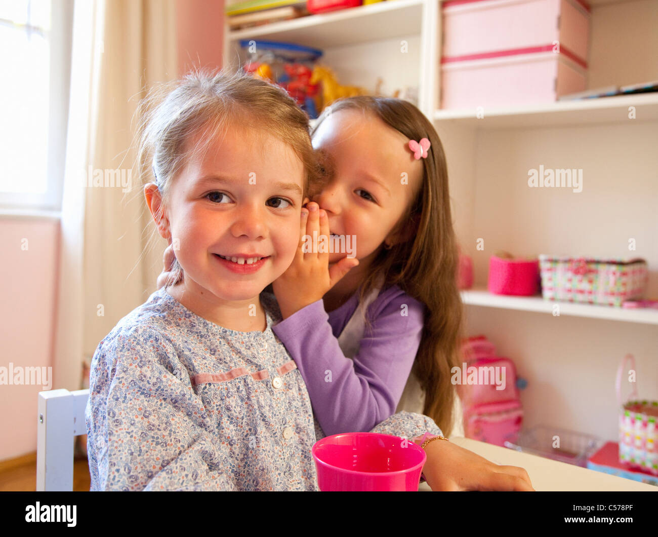 Girls whispering to each other Stock Photo - Alamy