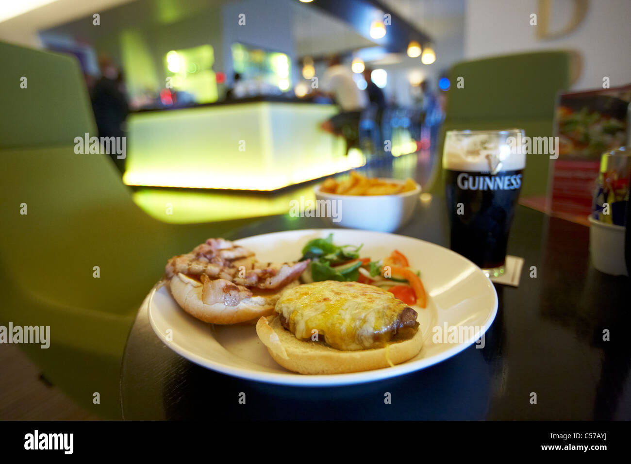 bacon and cheese burger served with salad fries and pint of guinness in a pub bar restaurant in dublin ireland Stock Photo