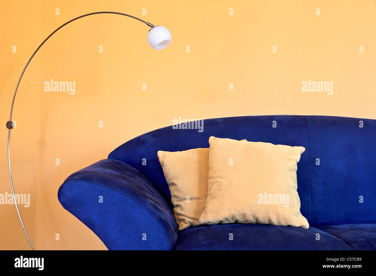 https://c8.alamy.com/comp/C57CB9/a-blue-sofa-with-reading-lamp-and-yellow-pillows-and-walls-C57CB9.jpg