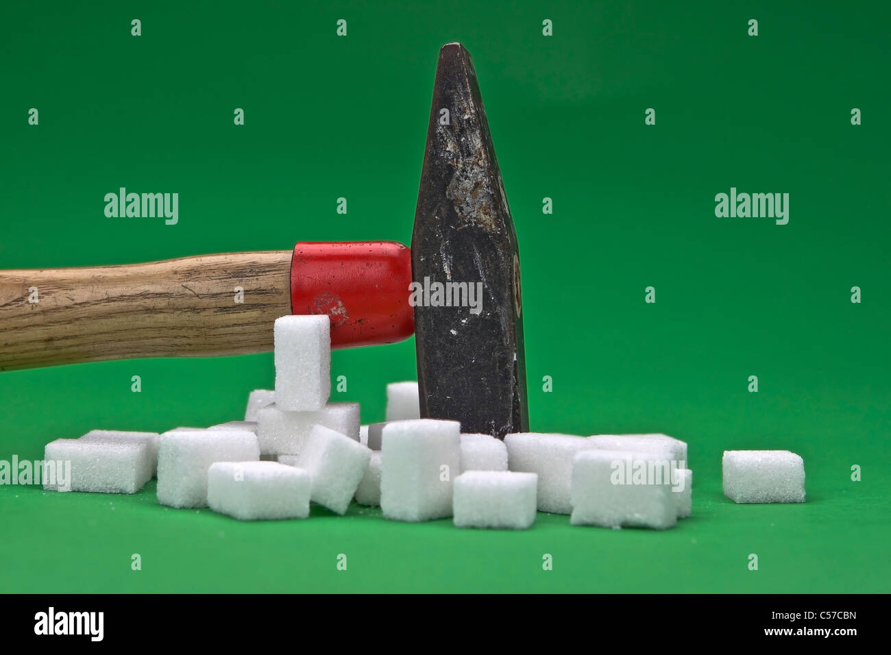 a hammer which is disturbing sugar cubes for a healthier nutrition in the future Stock Photo